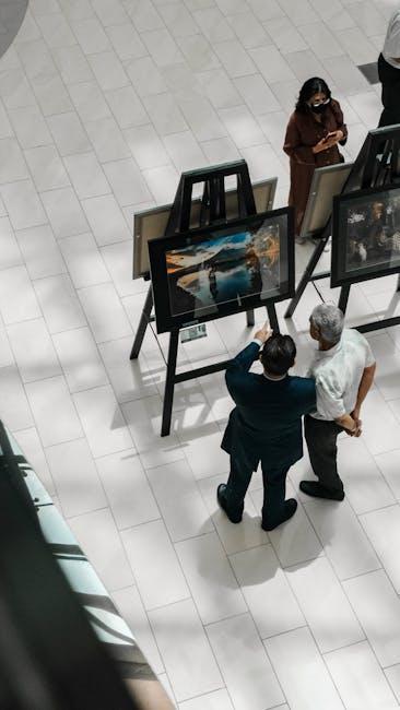 A high-angle view of people observing art exhibits in a gallery, showcasing creativity and culture.
