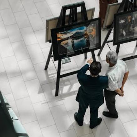 A high-angle view of people observing art exhibits in a gallery, showcasing creativity and culture.