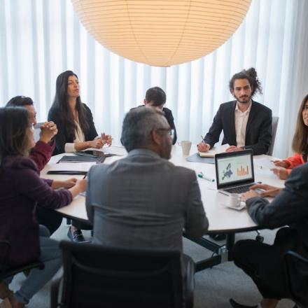 A diverse group of professionals discussing business strategy in a modern office setting.