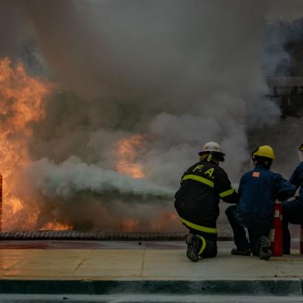 Brave firefighters practice extinguishing a controlled fire, showcasing teamwork and safety skills.