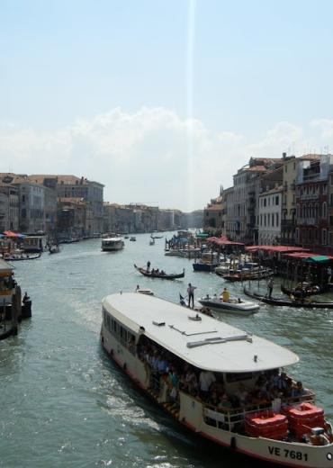 Explore Venice's Grand Canal with boats and historic buildings along the water.